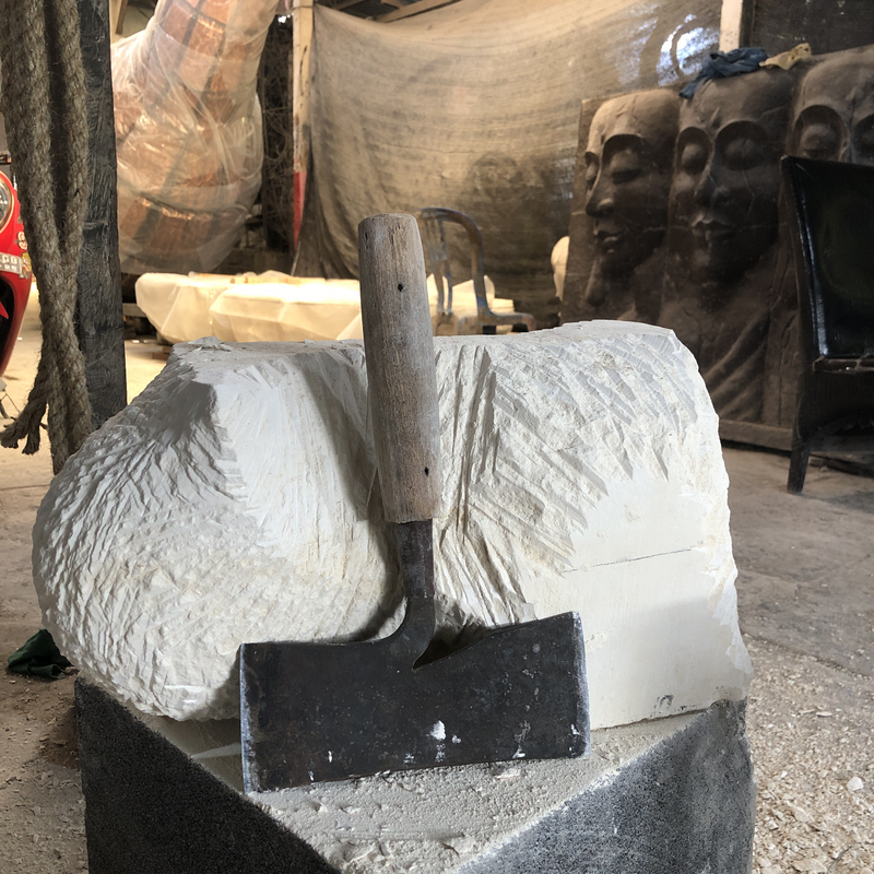 Caption: Patuk (Balinese stone axe) and the early stages of a sculpture made of Paras Jogja (limestone from Java). © Monika Majer]