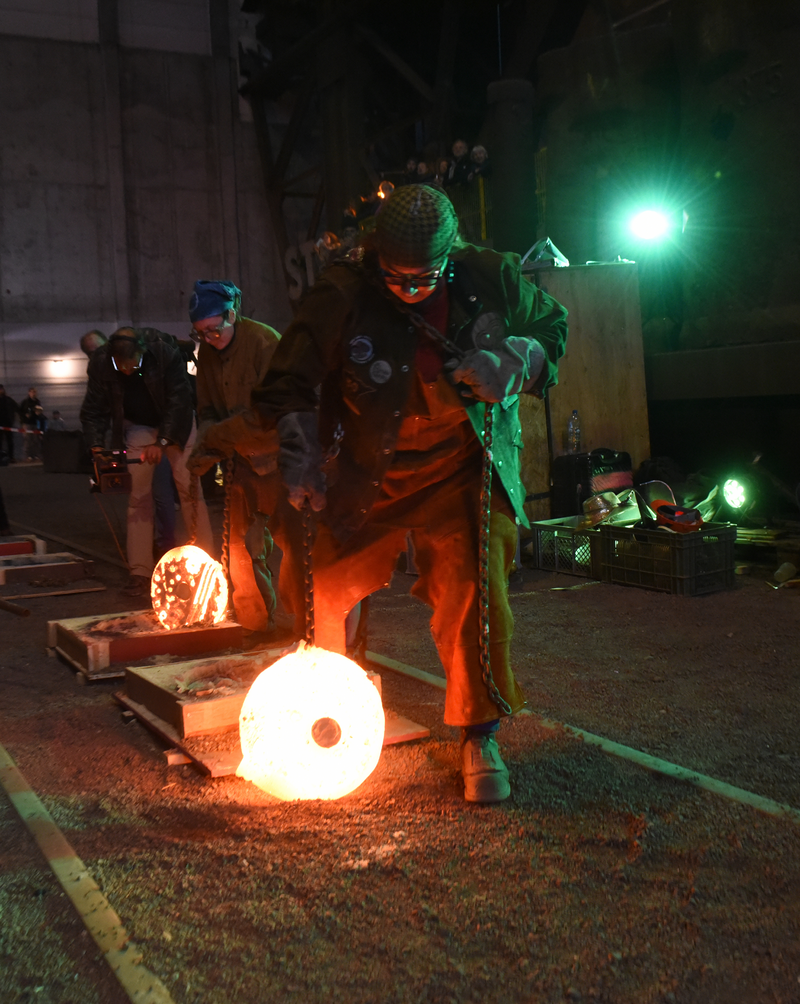 Coral Lambert: Garden of Fiery Delights. 2022, Molten cast iron performance on site at Industriemuseum Brandenburg an der Havel. Lambert taming the iron as part of the International Conference on Contemporary Cast Iron Art, Berlin 2022.