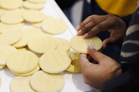 A visitor picks up and reads the braille on David Johnson’s Nuggets of Embodiment 2024/25  Photo Joanne Crawford
