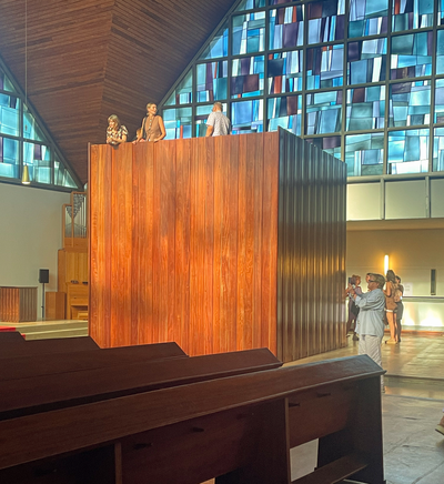manifesta26 Augustas Serapinas, Pew Tower, neu angeordnete Kirchenbänke, 480 × 400 × 400 cm und Lilli Lake, Rhythm looks for two, recyceltes Kupfer aus dem Ruhrgebiet, Papier, Holz, Lack, Messing, Markuskirche Essen